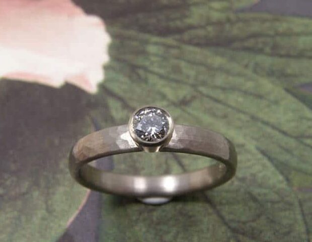 Verlovingsring, witgoud met fijne hamerslag en diamant. Ontwerp van Oogst sieraden in Amsterdam