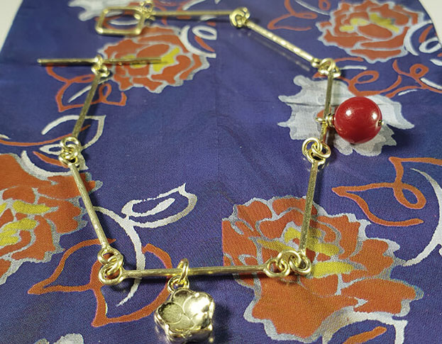 Geelgouden armband met bloesem en koraal. Yellow gold bracelet with a coral and with yellow gold flower. Japonais. Oogst goudsmid Amsterdam