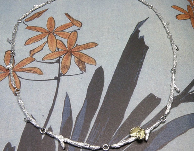 Zilveren takjes schakels met geelgouden blaadjes. Silver twigs necklace with yellow golden leafs. Oogst goudsmeden Amsterdam.