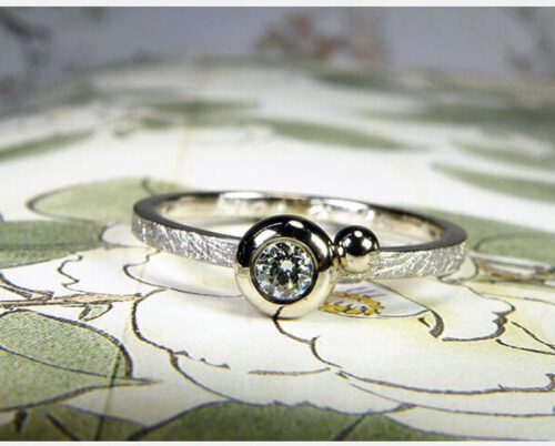 Verlovingsring 'Boleet'. Witgouden ring met een diamant en een bolletje ernaast. Engagement ring 'Boletus'. White golden ring with a diamond and a sphere. Uit het Oogst atelier Amsterdam.
