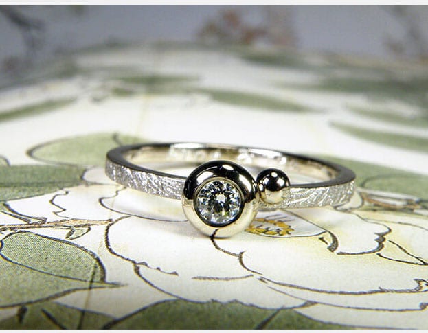Verlovingsring 'Boleet'. Witgouden ring met een diamant en een bolletje ernaast. Engagement ring 'Boletus'. White golden ring with a diamond and a sphere. Uit het Oogst atelier Amsterdam.