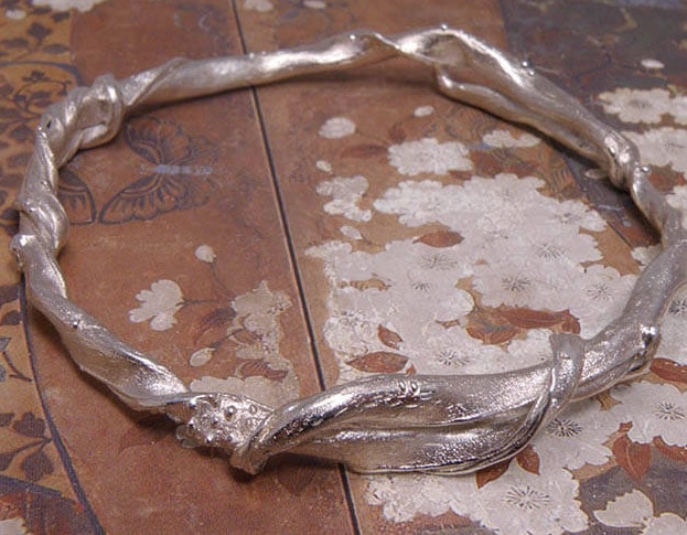 Zilveren armband van vervlochten takken. Silver bracelet of intertwined branches. Uit het Oogst atelier Amsterdam.