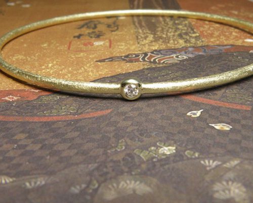 Armband 'Eenvoud' geelgouden rinkelband met eigen diamant. Bracelet ‘Simplicity’ yellow golden bangle with heirloom diamond. Uit het Oogst atelier Amsterdam.