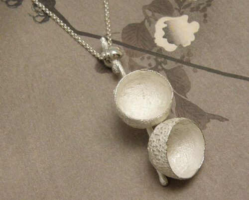 Zilveren hanger Eikendopjes met kevertje. Silver pendant Acorns with a ladybug. Uit het Oogst goudsmid atelier. Made in the Oogst goldsmith studio.