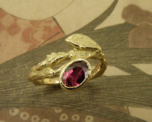 Engagement ring 'Orchard'. Yellow golden twig with leaf and oval ruby. Created in the Oogst studio in Amsterdam.