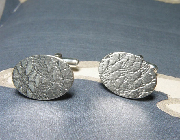 Silver oval shaped cufflinks with lace texture from the Patterns series. Jewellery design by Oogst in Amsterdam