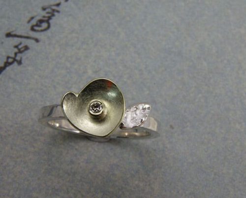 Zilveren ring met geelgouden kommetje en diamant. Silver ring with yellow gold cup and diamond. Uit het Oogst goudsmid atelier. Made in the Oogst goldsmith studio.