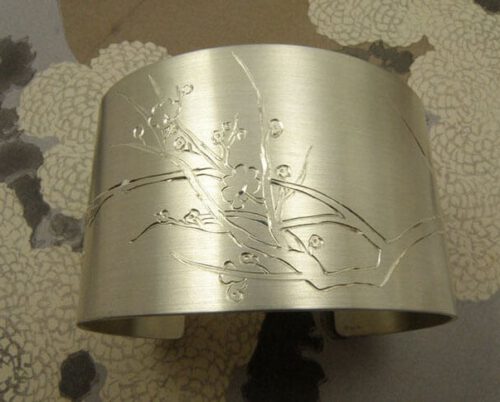 Zilveren klemarmband met handgegraveerde bloesems. Silver cuff with hand engraved blossoms. Uit het Oogst atelier Amsterdam.