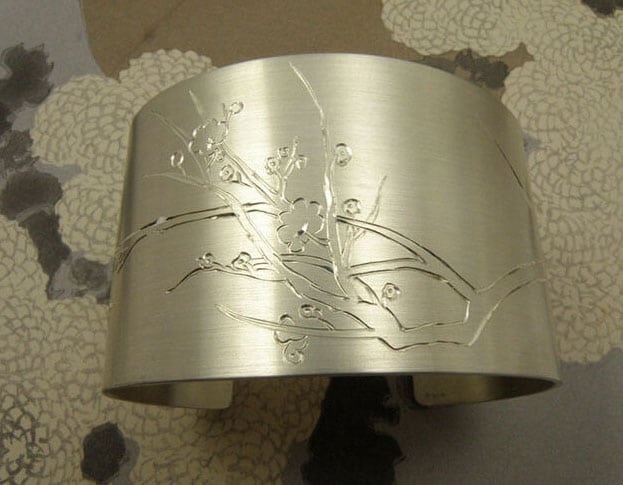 Zilveren klemarmband met handgegraveerde bloesems. Silver cuff with hand engraved blossoms. Uit het Oogst atelier Amsterdam.