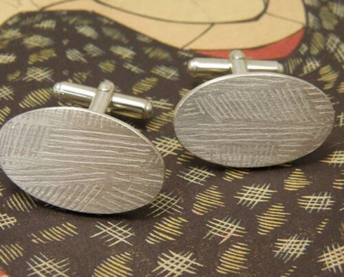 Sterling silver oval shaped pair of cufflinks with striped pattern from our Lineair series. Handcrafted by Oogst Jewellery in Amsterdam.