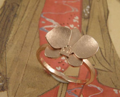 Roodgouden ring 'In Bloei' met een orchidee. Rose gold flower ring with an orchid. Uit het Oogst goudsmid atelier. Made in the Oogst goldsmith studio.