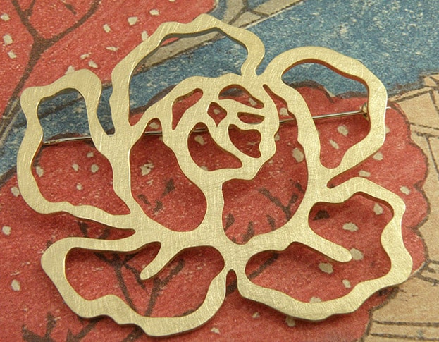 'In bloei' speld in de vorm van een roos, gemaakt van eigen goud. 'In bloom' pin in the shape of a rose, made from heirloom gold. Uit het Oogst atelier Amsterdam.