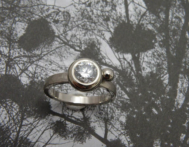 Ring 'Boleet' witgouden hamerslag ring met een eigen diamant uit een erfstuk met een speels bolletje ernaast. Ring ‘Boletus’ white golden ring with hammering, heirloom diamond and a playful sphere. Oogst goudsmeden Amsterdam.