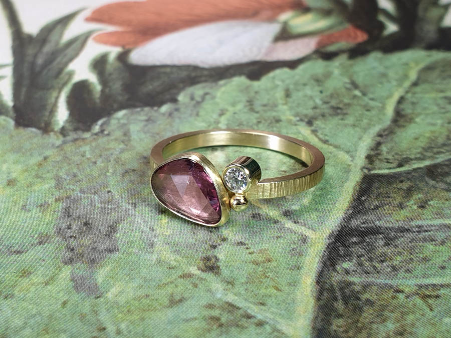 Blog about sapphire. Yellow gold ring with bordeaux korund and a diamond.  Design by Oogst studio in Amsterdam.