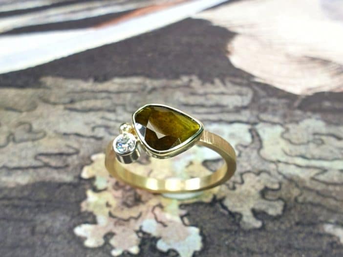Geelgouden 'Verzameling' verlovingsring met groene toermalijn en diamant. Uit het goudsmid atelier van Oogst in Amsterdam