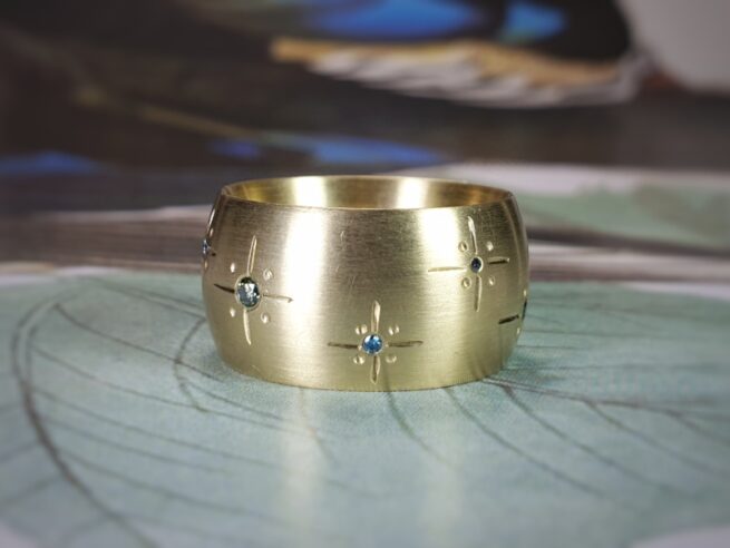 Geelgouden ring 'Eenvoud' met blauwe en groene diamanten. Ontwerp van Oogst goudsmeden in Amsterdam