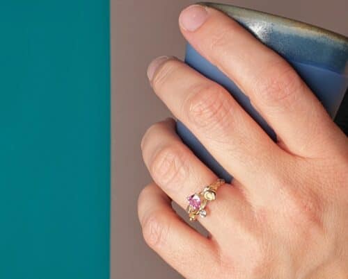 Geelgouden 'Twist' ring met een roségouden perzik, een kristal en 0,65 crt peergeslepen roze korund en 0,11 crt diamant brown . Ontwerp van Oogst goudsmid in Amsterdam voor de Amorf vs Kristallijn collectie.