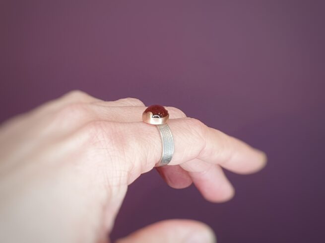 Witgouden 'Linnen' ring met rode toermalijn in roodgouden wolk zetting. Oogst goudsmeden Amsterdam.