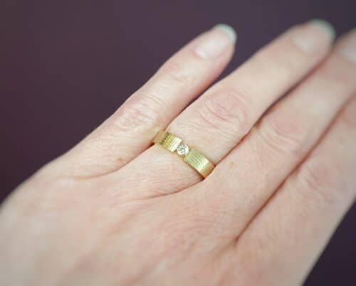 Yellow golden 'Linen' ring with a diamond. Design by goldsmith Oogst Amsterdam.