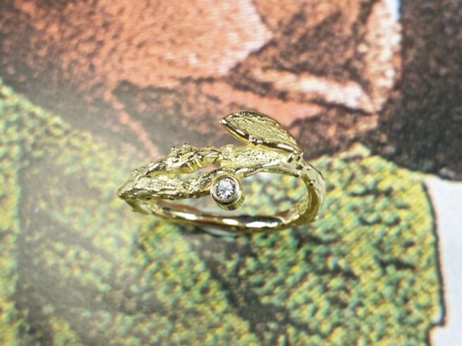 Geelgouden ring 'Boomgaard' weelderige takjes met blaadje en diamant.