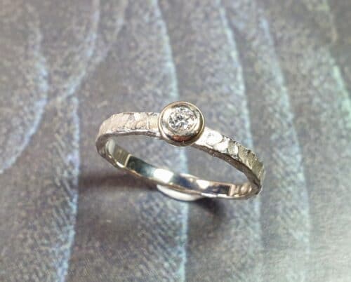 Engagement ring 'Swell'. White golden ring with texture and 0,10 ct diamond. Made at Oogst studio.