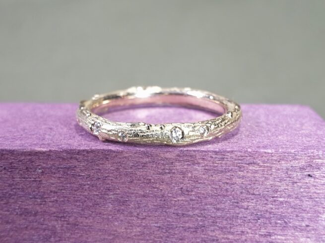 Geelgouden verlovingsring met diamanten rondom speels verdeeld gezet. Ontwerp van Oogst Sieraden in Amsterdam