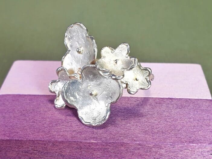 Zilveren ring met bloemen. Handgemaakte ring uit de 'In Bloei' serie van Oogst Sieraden in Amsterdam.