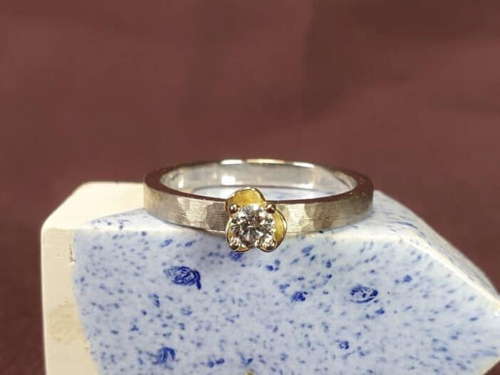 Diamantring uit de Ritme serie van Oogst Sieraden in Amsterdam. Witgouden ring met diamant en geelgouden bloem.