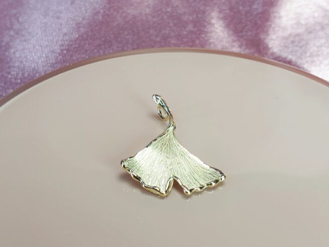 Geelgouden hanger Ginkgo blad aan een verfijnd ankerschakel collier. Handgemaakt door Oogst Sieraden.