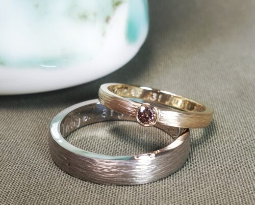 Trouwringen Ritme. Witgouden ring en roodgouden ring met bruine diamant met spitse hamerslag. Maatwerk van Oogst Goudsmeden