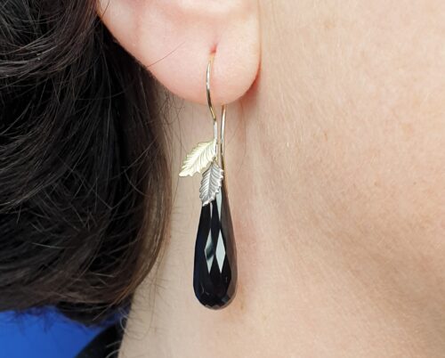 Yellow gold and white gold ‘Leaves’ earrings with sparkling drop shaped onyx. Design by Oogst Jewellery in Amsterdam
