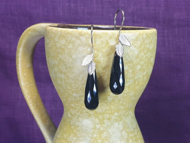 Yellow gold and white gold ‘Leaves’ earrings with sparkling drop shaped onyx. Design by Oogst Jewellery in Amsterdam