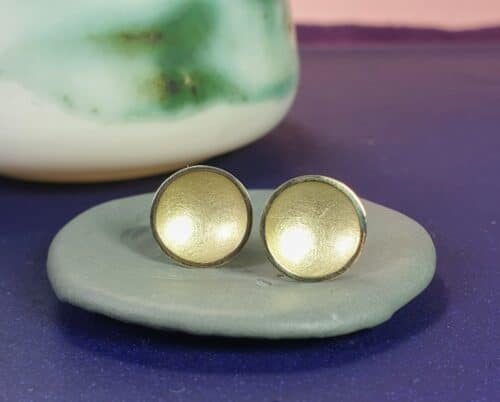 Golden ear studs from the 'Circles' series. Design by Oogst Jewellery in Amsterdam