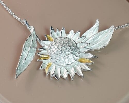 Assieraad. Zilveren Zonnebloem collier met bladgoud details. Maatwerk van Oogst Goudsmeden in Amsterdam