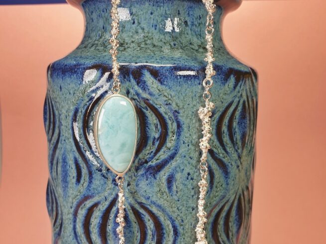 Zilveren Bessen collier met een larimar ornament. Lange ketting met kleurrijk detail. Ontwerp van Oogst Sieraden in Amsterdam.