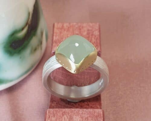 Silver ring 'Rhythm' with a cushion cabochon cut aquamarine, which is set in yellow gold. Sturdy statement men's ring design by Oogst Jewellery in Amsterdam.