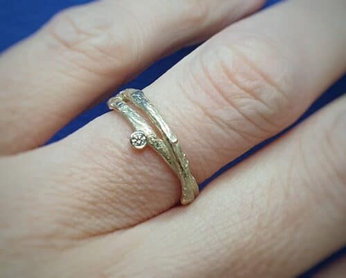 Geelgouden ring uit de Boomgaard serie, overkruist takje met diamant. Ontwerp van Oogst Sieraden in Amsterdam