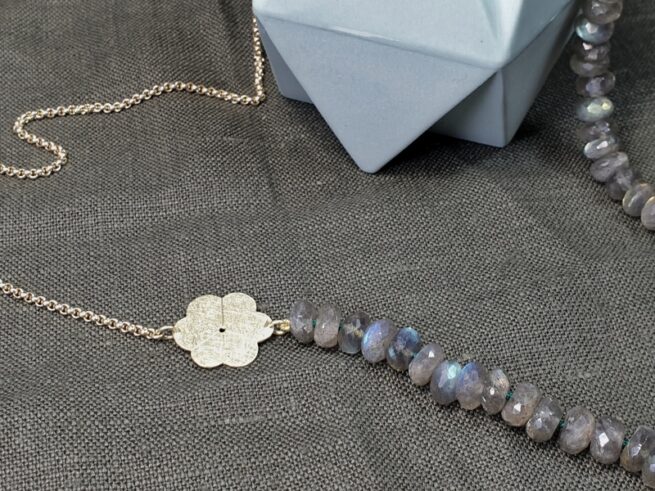Golden Japonais necklace with a sleek blossom and sparkly labradorite. Design by Oogst Jewellery in Amsterdam