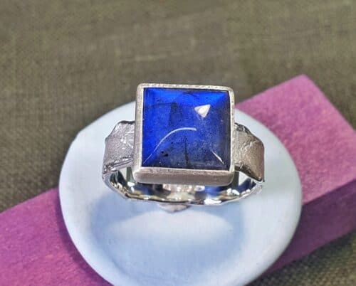 Silver ring from the ‘Erosion’ series with a shimmering square cut labradorite. Design by Oogst goldsmith in Amsterdam