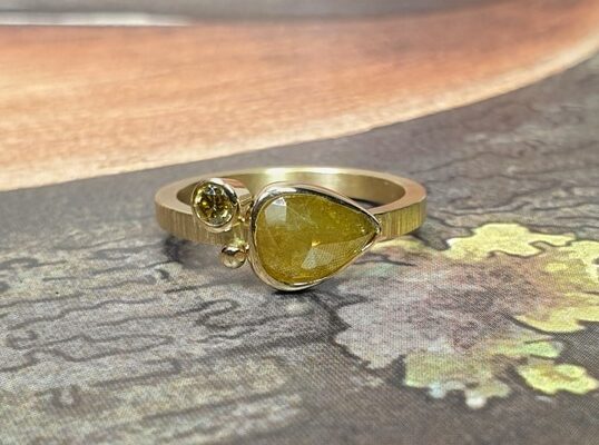 Ring 'Verzameling'van eigen goud vervaardigd met spitse hamerslag en een 1,21 ct mosterd natural diamant en een 0,10 ct briljant geslepen diamant olijf. Maatwerk uit het Oogst atelier in Amsterdam.