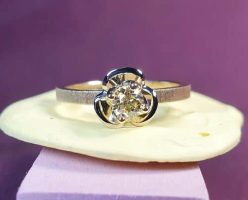 Geelgouden ring 'In bloei' met 0,23 crt briljant geslepen diamant cape op een bloempje gezet. Ontwerp van Oogst Goudsmeden in Amsterdam