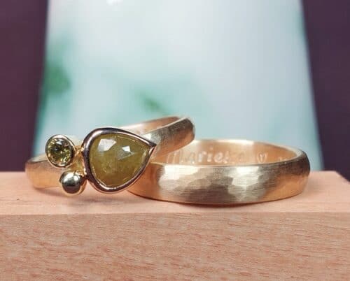 Trouwring 'Verzameling' en 'Ritme'. Roségouden gehamerde ringen. Met voor haar een 0,11 crt diamant olijf en een 0,86 crt peer vorm natural diamant groen. Uit het Oogst atelier in Amsterdam