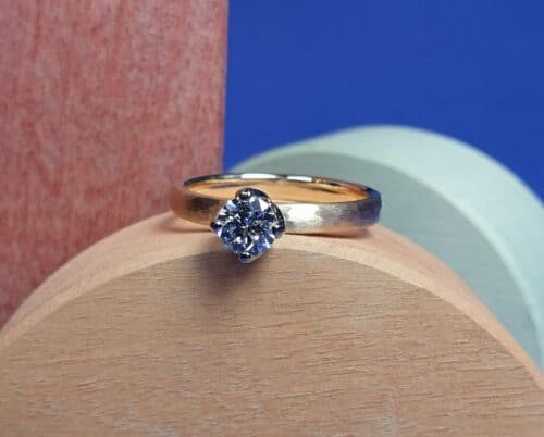 Verlovingsring 'Ritme': roségouden ring met hamerlsga en een 0,42 ct briljant geslepen diamant in een witgouden chaton. Maatwerk uit het Oogst Goudsmeden atelier in Amsterdam.