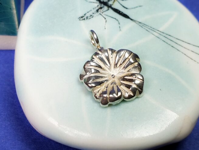 Silver 'In bloom' pendant. A curvy lined flower shape, created at the Oogst goldsmith studio.