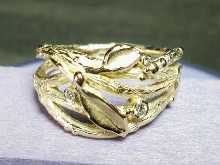 Geelgouden Takjes ring uit de Boomgaard serie met takjes, blaadjes, besjes en diamanten. Uniek ontwerp van Oogst Goudsmeden in Amsterdam