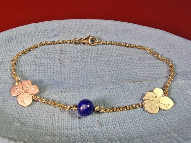 Golden braclet Mackintosh with Lapis Lazuli  in yellow & rosé gold. Blackthorn flower with hand engraving. Jewellery design by Oogst in Amsterdam.