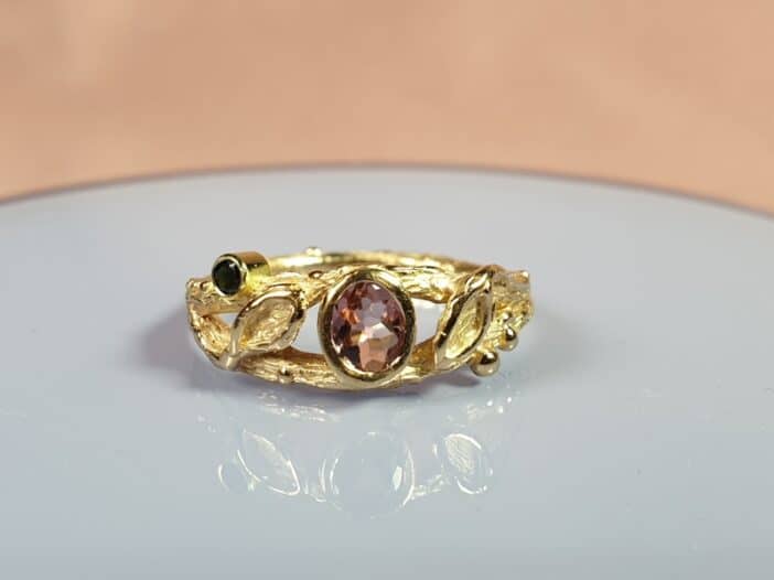 Geelgouden Boomgaard ring met roze en zwarte toermalijn en blaadjes. Maatwerk voor Annaleid van Oogst goudsmid in Amsterdam