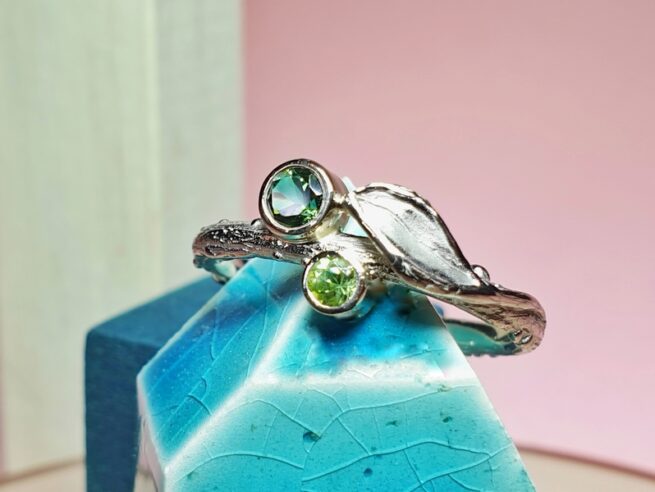 Playful 14 crt palladium white gold twig ring with a cute leaf and a tourmaline and peridote. Jewellery design by Oogst in Amsterdam