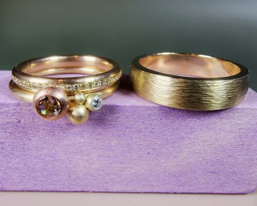 Verzameling Eenvoud en Ritme trouwringen. Speelse geelgouden ring met diamanten, een strakke roségouden ring met rondom diamanten gezet en een strakke geelgouden ring met spitse hamerslag. Uit het Oogst atelier.