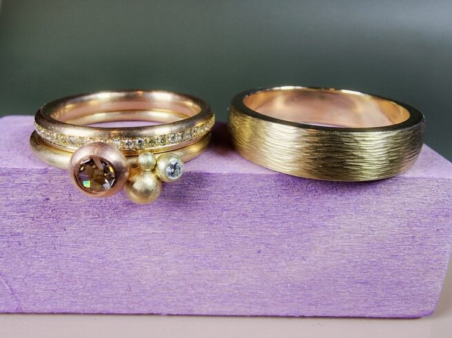 Verzameling Eenvoud en Ritme trouwringen. Speelse geelgouden ring met diamanten, een strakke roségouden ring met rondom diamanten gezet en een strakke geelgouden ring met spitse hamerslag. Uit het Oogst atelier.